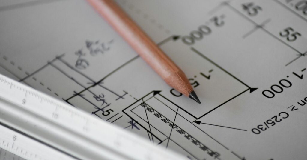 Pencil and ruler on a technical drawing representing specification revision review