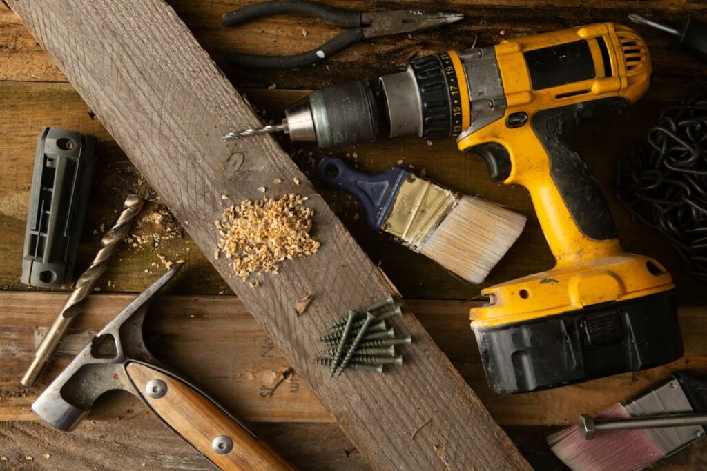 Cordless drill and hand tools on a wooden workbench illustrating power tools and workshop equipment